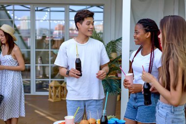 Sıradan yaz kıyafetleri içinde güzel genç kadınlar ve erkekler parti boyunca eğlenin.