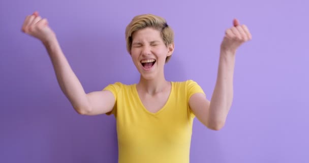 Ganar éxito mujer feliz éxtasis celebrando ser un ganador. aislado en púrpura — Vídeo de stock