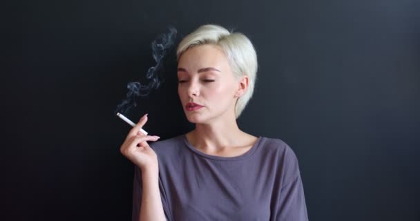 Siyahların üzerinde izole edilmiş sigara içen genç kadınlara yeni elektronik sigara ve e-sigara sunuluyor. — Stok video
