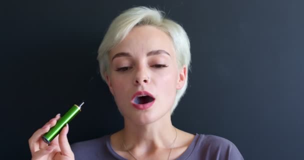 Nuove sigarette elettroniche, e-sigaretta in mani femminili, donna dai capelli corti che fuma — Video Stock