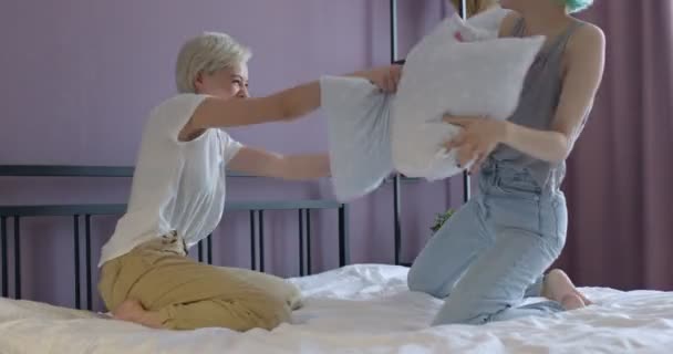 Ziemlich sexy lesbisches Paar hat Spaß mit Kissen im Bett am Morgen am Valentinstag — Stockvideo