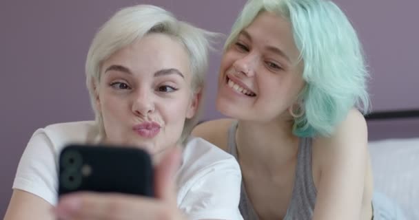 Молоді милі бікіні лесбіянки використовують смартфон селфі на ліжку з щастям — стокове відео