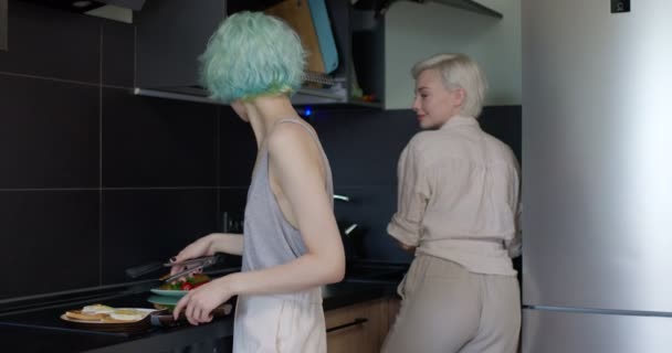 Twee lesbische vriendinnen maken maaltijd in de keuken in de ochtend, communiceren — Stockvideo