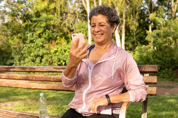 Mulher Brasileira Negra Sênior Usando Celular Inteligente Sorrindo Fora Parque — Fotografia de Stock