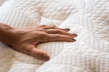 Mahalle ticaretinde yatağın yumuşaklığını kontrol eden bir elin ayrıntıları