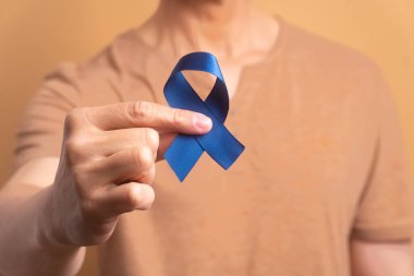 Stüdyoda mavi kurdele gösteren Brezilyalı adamın elleri. Prostat kanseri, farkındalık kavramı.