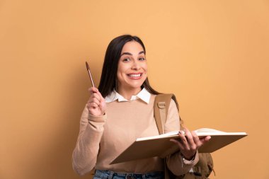 Mutlu üniversite öğrencisi bej renklerle cevap vermek için elini kaldırıyor. öğrenim, okul, öğrenci hayatı konsepti.