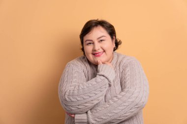 Gülümseyen ve bej renkli kameraya bakan neşeli Brezilyalı kadın. Portre, gerçek insanlar konsepti..