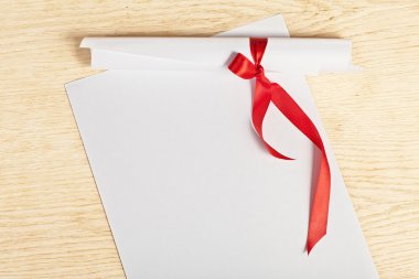 Kağıt ahşap yüzeye kırmızı kurdele ile kaydırma.