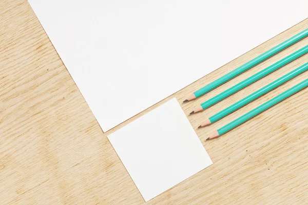 Leeres Papier mit Bleistiften auf einer Holzoberfläche. — Stockfoto
