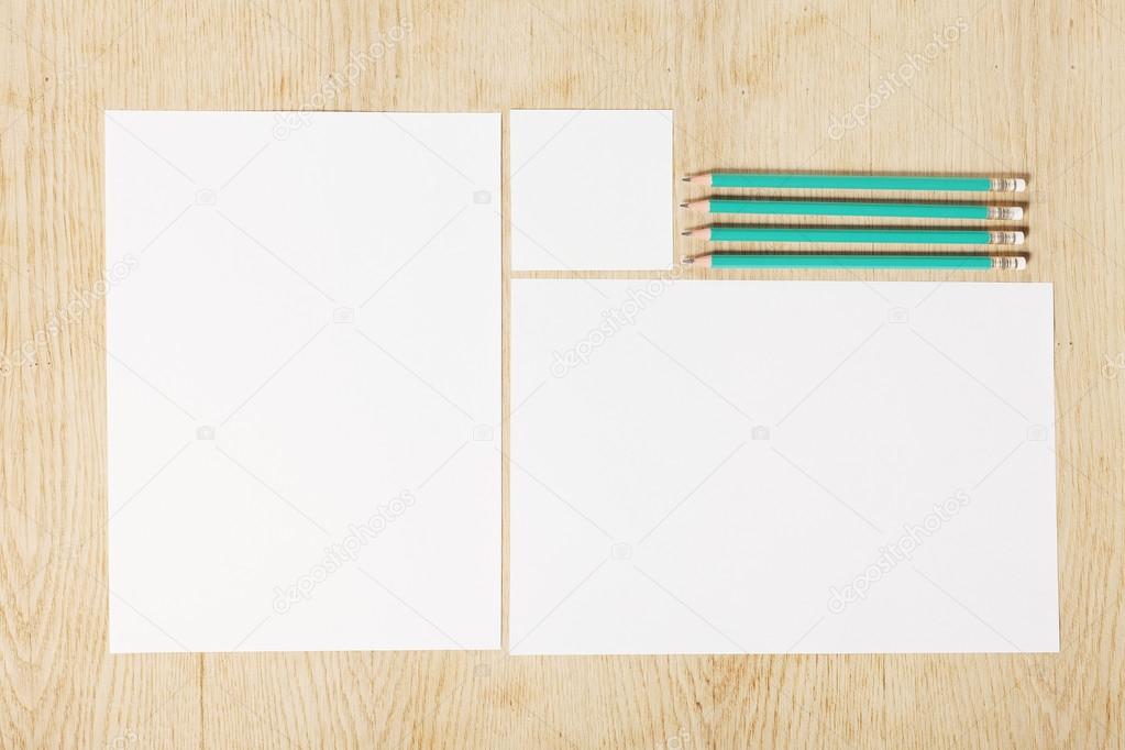 Blanks of empty paper with pencils on a wooden surface. 
