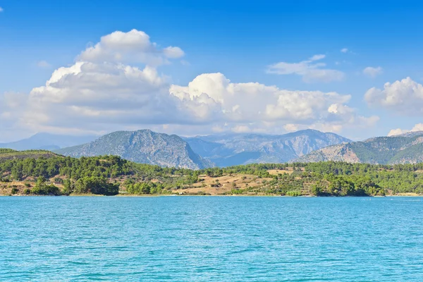 Blick von der Wasserseite auf die Küste und die Berge. Stockbild