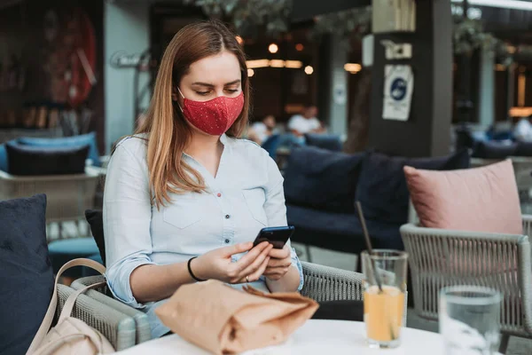 Jonge Vrouw Het Gezicht Masker Met Behulp Van Smartphone Cafe — Stockfoto