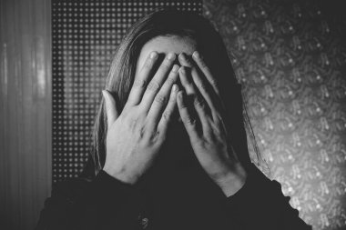 Yüzünü elleriyle kapatan kadın portresi 