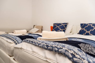 Yastıklı yatak odası ve beyaz havlular.