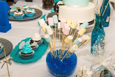 Çocukların doğum günü pastası. Süslü masada üzerinde mavi ve beyaz kekler var.