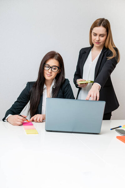 Two Happy coworkers smiling and working on laptop in office