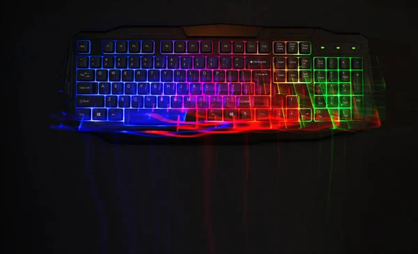 Gaming keyboard with led lights leak on black background