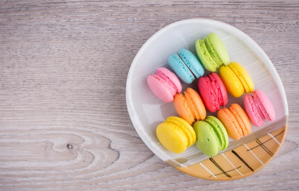 Sweet colorful macaroons on a wood background — Stock Photo, Image