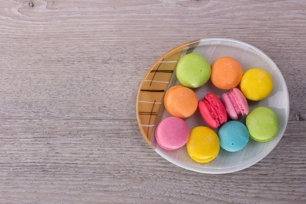 Macarrones dulces y coloridos sobre un fondo de madera — Foto de Stock