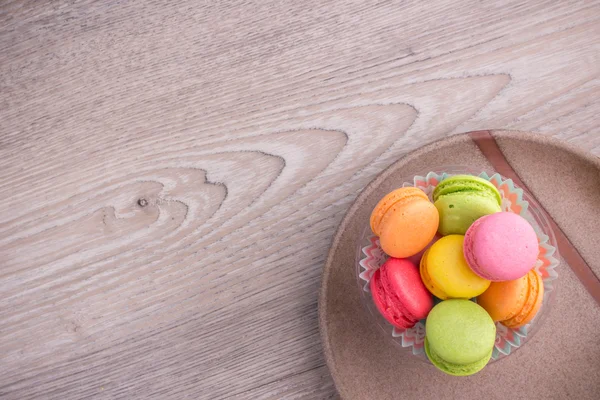 Macaroons coloridos doces em um fundo de madeira — Fotografia de Stock
