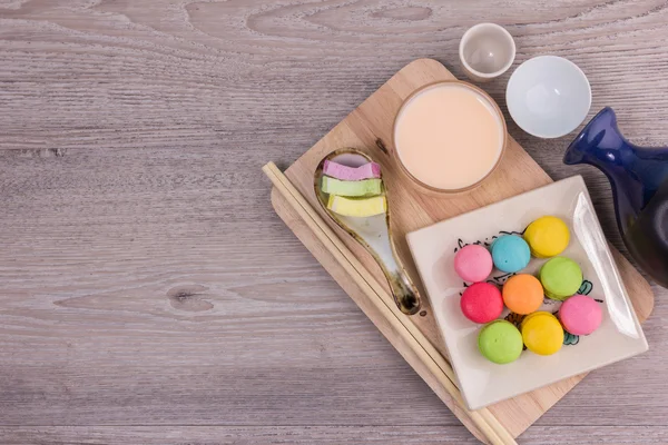 Macarrones dulces y coloridos sobre un fondo de madera — Foto de Stock