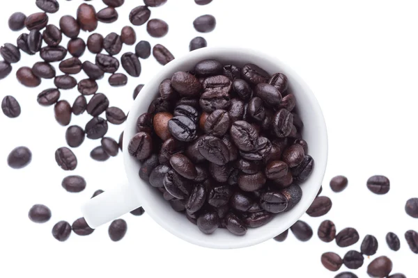 Granos de café en taza de cerámica aislada en fondo blanco — Foto de Stock