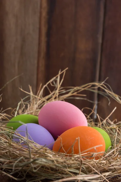 Œufs de Pâques dans le nid sur un vieux fond en bois — Photo