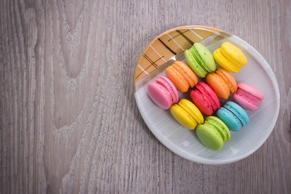 Macaroons coloridos doces em um fundo de madeira — Fotografia de Stock