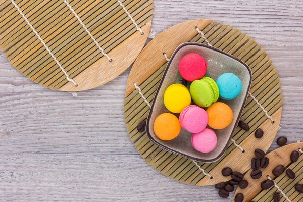 Macarrones dulces y coloridos sobre un fondo de madera — Foto de Stock