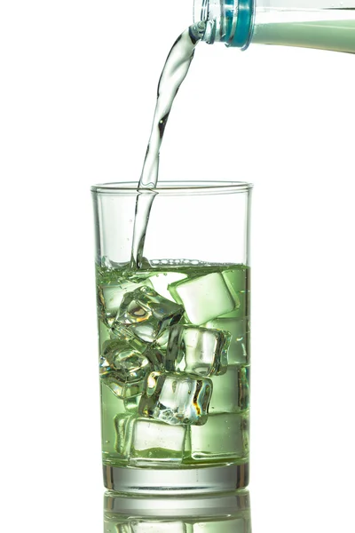 Water is gegoten in een glas met ijsblokjes — Stockfoto