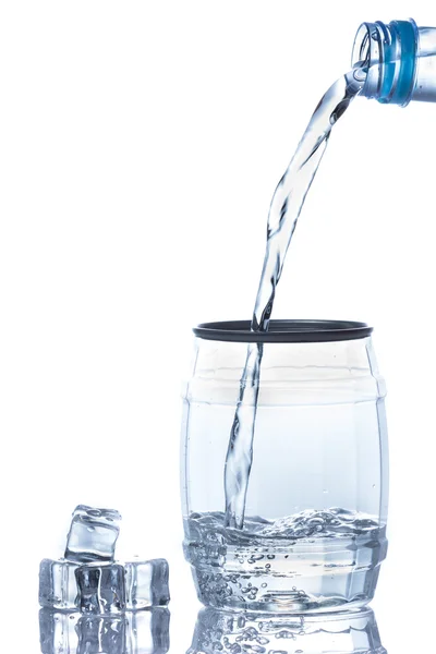 Water is gegoten in een glas met ijsblokjes — Stockfoto