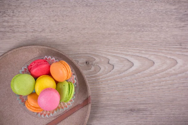 Macaroons coloridos doces em um fundo de madeira — Fotografia de Stock