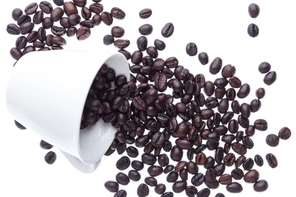Granos de café derramados de la taza de cerámica blanca — Foto de Stock