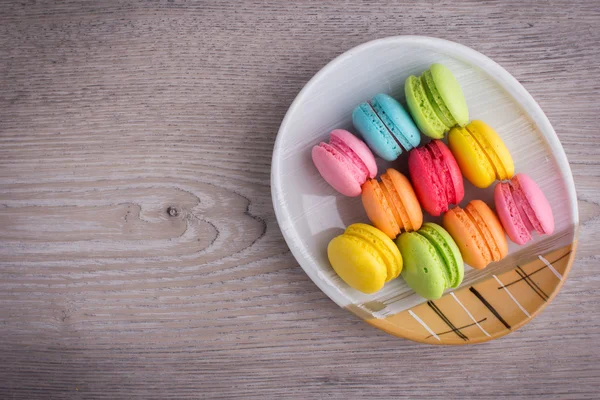 Sweet colorful macaroons on a wood background — Stock Photo, Image