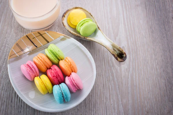 Macaroons coloridos doces em um fundo de madeira — Fotografia de Stock