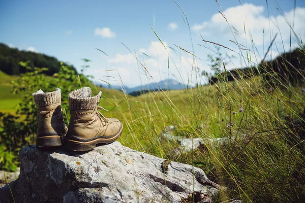 Velhas botas de caminhada na rocha — Fotografia de Stock