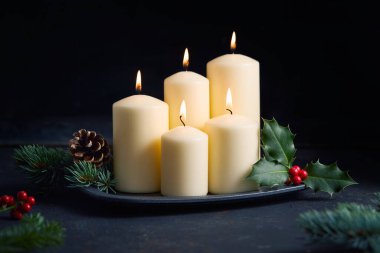 Kutsal yapraklarla yanan mumlar, kırmızı böğürtlenler ve çam dalları sıcak bir Noel atmosferi yaratıyor..