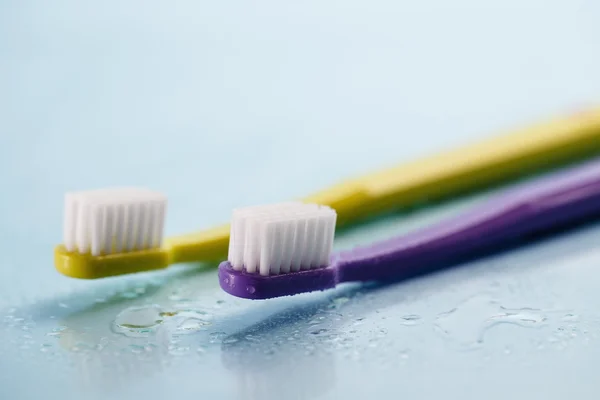 Toothbrushes on wet surface — Stock Photo, Image