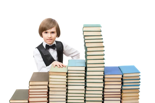 Niño en pilas de libros antiguos —  Fotos de Stock