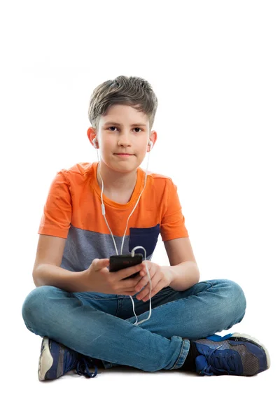 Een schooljongen is luisteren muziek — Stockfoto