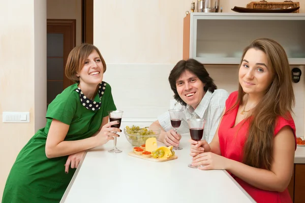 Três jovens bebem vinho — Fotografia de Stock