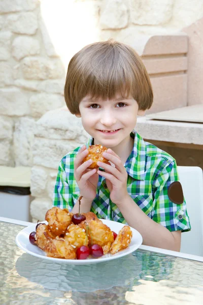 Kleiner Junge mit süßen Kuchen — Stockfoto