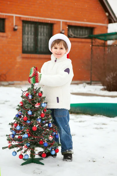 Garoto sorridente com árvore Cristmas — Fotografia de Stock