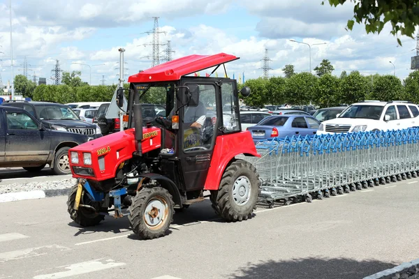 Tractor llevar a cabo fila de carros de compras —  Fotos de Stock