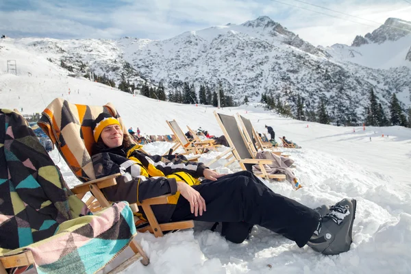 Mann sitzt in Alpin-Skigebiet — Stockfoto