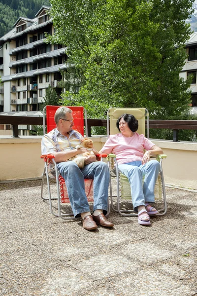 Couple is resting on balcony with cat — Stock Photo, Image