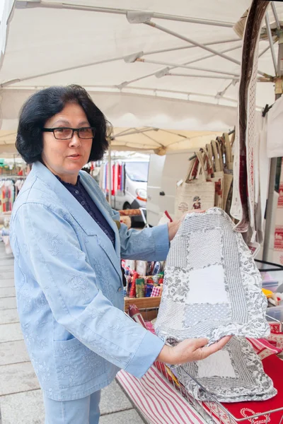 Женщина смотрит полотенца на рынке — стоковое фото
