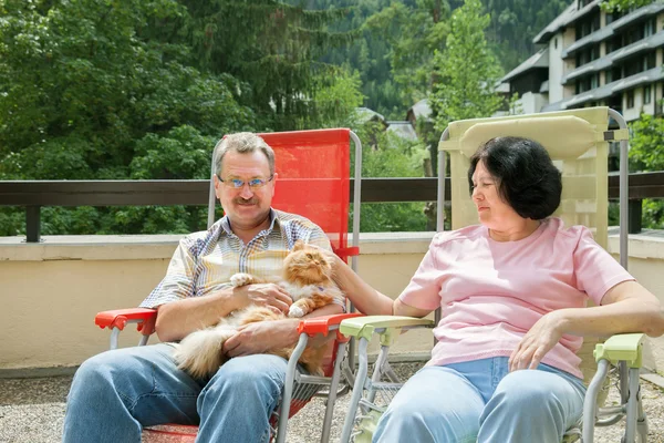 Couple is resting on balcony with cat — Stock Photo, Image