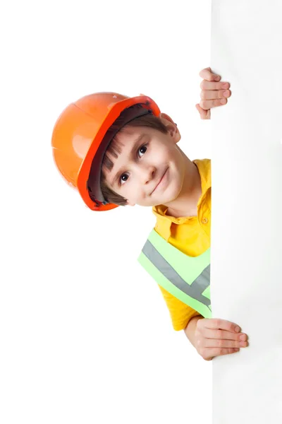 Kleine jongen in veiligheidshelm met lege billboard — Stockfoto